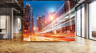 Abstract image of a modern night city with traces of headlights from cars on the highway on a background of skyscrapers Wall mural