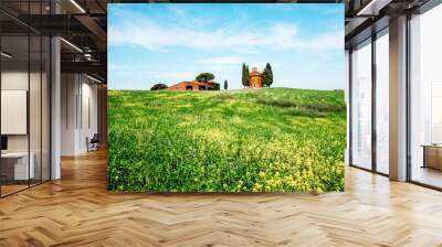 charming landscape with rape flowers and chapel of Madonna di Vitaleta in background on a sunny day in San Quirico d'Orcia (Val d'Orcia) in Tuscany, Italy. Excellent tourist places Wall mural