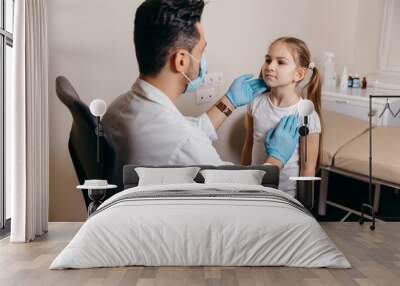 Arab or Turkish doctor examines a little girl before vaccination Wall mural