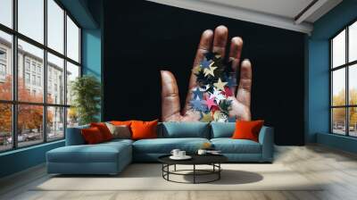 Female hand holding stars confetti, black background Wall mural