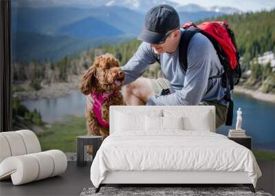 Dog catching breath with man on mountain hike Wall mural