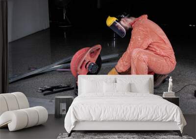 A man wearing safety mask and suit is cutting metal Wall mural