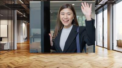 Business asian woman greeting while coming in office in morning Wall mural