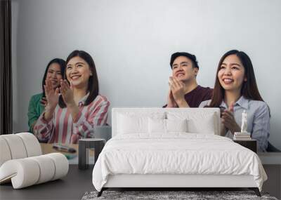 Group of asian working people wearing casual business shirt, sitting, meeting in indoor seminar room, doing workshop, giving applause with happiness and success. Wall mural