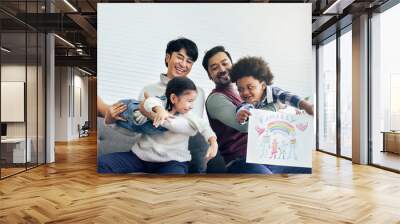 Male gay taking care adopted children who are happy diverse little Caucasian girl and African boy, playing with fun, drawing family picture, sitting on sofa in living room at home. LGBT, kids Concept. Wall mural