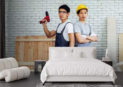 Portrait two young Asian handsome male carpenters or woodworkers helping each other, making DIY wooden furniture in indoor factory. Teamwork, Business, Interior and Industry Concept. Wall mural