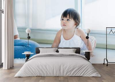 Selective focus adorable caucasian little baby daughter girl, smiling, crawling on the floor, playing alone in comfortable living room at home or house with happiness. Kid Development Concept. Wall mural