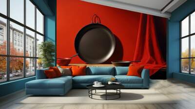  a painting of a frying pan and two bowls on a table with a red wall in the background and a red curtain in the foreground with a red curtain. Wall mural