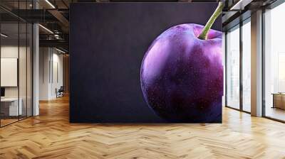   A purple apple with a stem extending from its center on a black background Wall mural