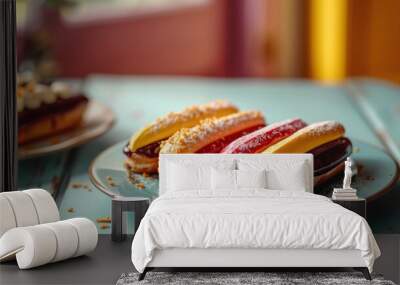  a table topped with two plates filled with hot dogs and buns covered in frosting next to a plate of cookies and marshmallows on a blue table. Wall mural