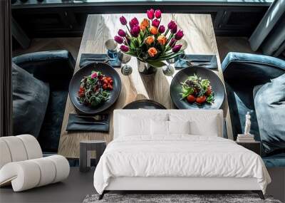   A table topped with two plates of food, next to a vase of tulips and another vase of tulips Wall mural