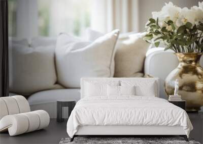  a vase filled with white flowers sitting on top of a table next to a table with two candles and a vase of flowers on top of a table next to a couch. Wall mural