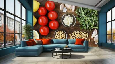   A wooden table with lemons, tomatoes, garlic, and other foodstuffs on top Wall mural