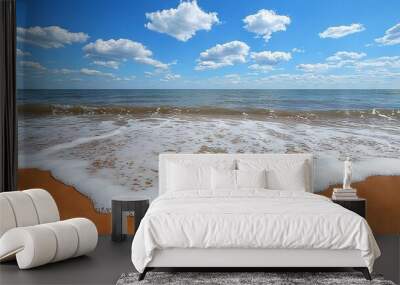   Beach with incoming wave, blue sky with white clouds Wall mural