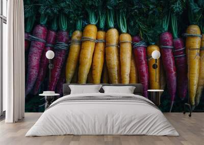   Carrots arranged together on green vegetable pile on table Wall mural