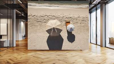  two beach umbrellas sitting on a sandy beach next to the ocean.  generative ai Wall mural