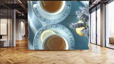   Two cups of tea with lemons and lavender on a blue and white tablecloth with a vase of flowers Wall mural