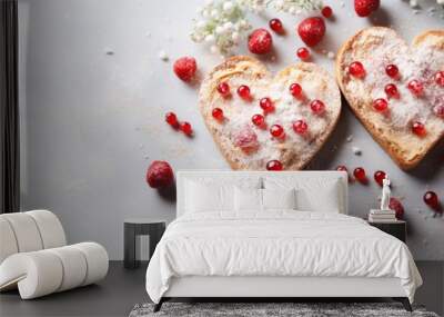  two heart shaped pieces of bread covered in powdered sugar and raspberries on top of a white surface. Wall mural