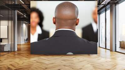 A businessman in a suit sits with his back to the camera, engaged in a discussion with two colleagues in a contemporary office. The atmosphere is professional and collaborative Wall mural