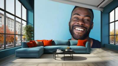 A charming man, his casual attire and vibrant, carefree smile suggest a welcoming and optimistic personality.. Wall mural