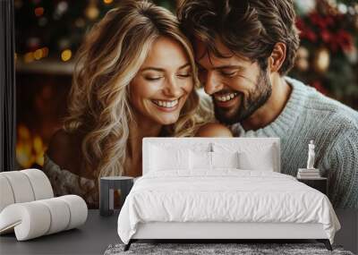 A cozy couple enjoying a warm holiday moment by the fireplace, holding mugs of hot chocolate Wall mural