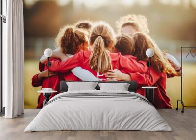 A group of girl soccer players is celebrating victory on the football field. Wall mural