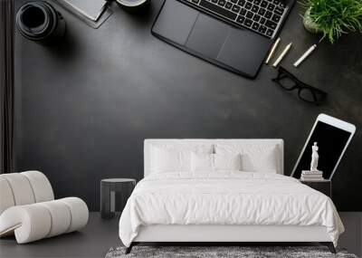 A neatly organized modern workspace featuring a laptop, smartphone, glasses, coffee, and stationery on a dark desk. Wall mural