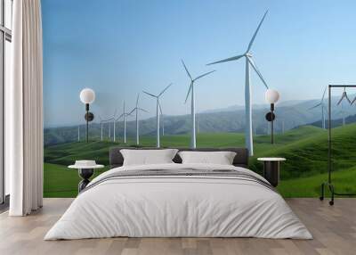 A row of wind turbines stand tall on a green hillside, generating clean energy under a clear blue sky Wall mural