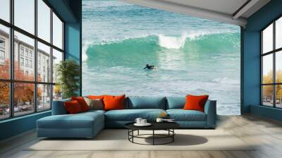 A surfer getting ready for the surf, going surfing in ocean Wall mural