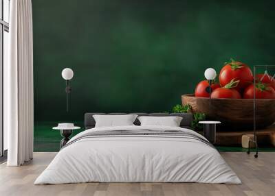 A wooden bowl brimming with vibrant red tomatoes sits next to fresh parsley on a rustic surface, beautifully contrasting with the deep green backdrop, ideal for a cooking theme Wall mural