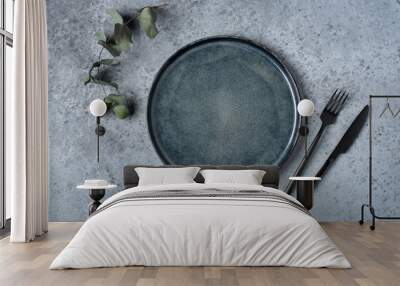 An empty plate and cutlery on a gray table. Top view. Wall mural