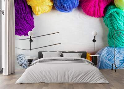 Balls of colored yarn on a white wooden background. Top view. Wall mural