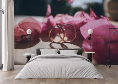 Bride's morning and wedding details. Wedding gold rings on a stone surface in bougainvillea flowers Wall mural