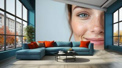 Close-up of smiling woman with blue eyes and freckles Wall mural