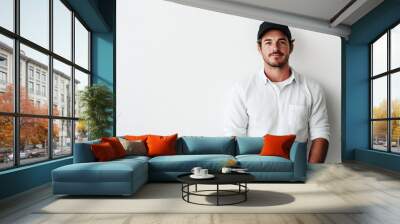 Confident man in cap leaning on white wall Wall mural