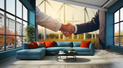 Cropped closeup of a handshake between two businessmen with a wind turbines background  Wall mural