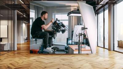 Director of photography with a camera in his hands on the set. Professional videographer at work on filming a movie Wall mural