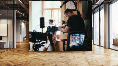 Director of photography with a camera in his hands on the set. Professional videographer at work on filming a movie Wall mural