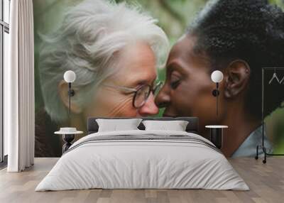 Elderly lesbian women in loving embrace in lush garden background, touching foreheads and smiling warmly. Concepts of love, affection, and companionship in later life. Wall mural