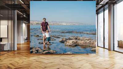 Father with a small son traveling near the sea. Wall mural