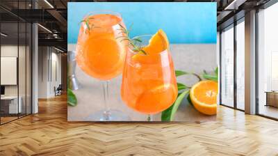 Classic italian aperitif aperol spritz cocktail in two wineglasses with ice cubes and slice of orange with light blue background on beige stone background, traditional summer fresh iced drink, closeup Wall mural