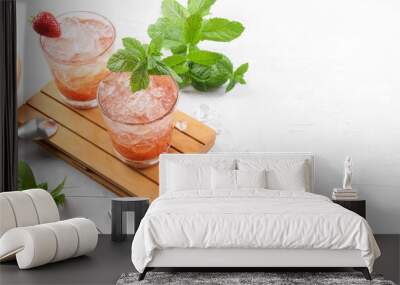 Cold summer strawberry cocktail mojito, margarita, daiquiri. Two glasses with fresh strawberry soda drink with ice cubes and mint leaves on light grey background. Iced strawberry lemonade, copy space Wall mural