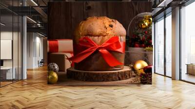 Traditional Italian Christmas Cake Panettone with red bow and festive decoration on wooden rustic background. Homemade artisan sourdough panettone is classic italian Christmas Food and Edible gift Wall mural