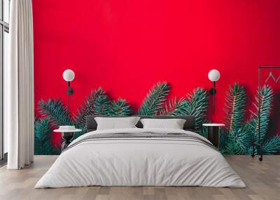 Fir branches on red background. Christmas wallpaper. Flat lay, copy space. Wall mural