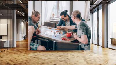 Friends play a board game in the living room Wall mural