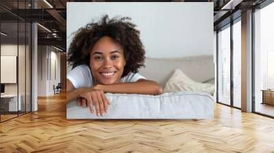 happy young african american woman relaxing and lying on the sofa at home white background Wall mural