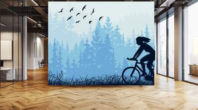 Horizontal banner. Silhouette of girl riding bike on meadow in forrest. Silhouette of biker, trees, grass. Magical misty landscape, fog. Blue illustration. Bookmark. Wall mural