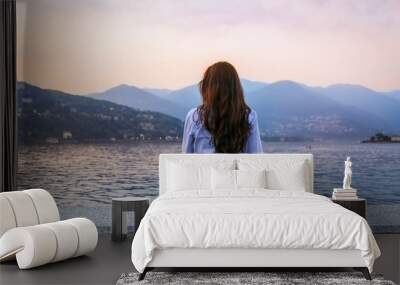 Young woman admiring sunset at the lake Como Wall mural