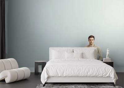 Man sitting with laptop in minimalistic setting Wall mural