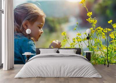 Baby enjoying flowers aroma Wall mural